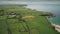 Irish aerial green fields landscape shot: road along meadows. Ireland wide plants and farms