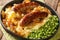 Irish Bangers and Mash is a dish consisting of sausages served with mashed potatoes and onion gravy closeup in the plate.