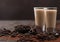 Irish cream baileys liqueur in shot glasses with coffee beans and powder with dark chocolate on dark wood background