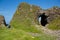 Irish landscape, green grass and cave-like rock formations, hiking family