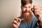 Irish redhead man with beard holding dental invisible aligner for tooth correction annoyed and frustrated shouting with anger,