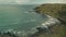 Irish rock ocean coast aerial view: green grass valleys, farmlands, rare waves on bay water front