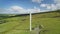 Irish wind mill timelapse aerial view: blades rotation. Beautiful rural landscape with fluffy clouds