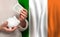 Irish woman with money bank on the background of Ireland flag. Dotations, pension fund, poverty, wealth, retirement concept