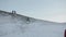 Irkutsk Region, Russia - March 18, 2021: A group of tourists descends from a snow-covered hill against the background of