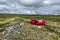 Irl is relaxing in red airlounger, the desert landscape of Remdalen Valley in highlands of Oppland, Norway