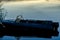 Iron boat stands at night on the pier against the background of calm water