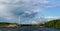 Iron bridge communications , linking the banks of the river are covered with forest on a Sunny day with clouds in the