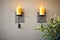 iron candle sconces on a textured stucco wall