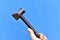 Iron claw hammer in hand on a blue background