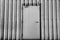 Iron door on corrugated metal sheet, black and white photo