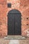 Iron door in a red brick wall. Gothic castle of Pomeranian dukes