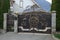 iron  gate with a brown forged pattern and a gray fence