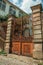 Iron gate covered by rust in front of old mansion