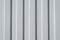 Iron, gray construction profiled sheet with vertical stripes. Closeup of a corrugated building material waiting for fences and