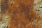 Iron leaf covered with strong deep red and brown rust with sand and stones. The texture of corrosion, wear and