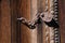 Iron lock on a solid chain hanging on a wooden gate