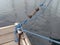 Iron mooring with blue ropes and rope tensioner. Nautical lines close up. Mooring yacht rope with a knotted end tied around a