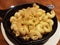 Iron pan with cheesy macaroni with breading