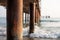 iron poles, wooden pier, waves splashing around the beach