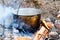 Iron pot with food on a burning fire. Food in a metal cauldron i