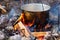Iron pot with food on a burning fire. Food in a metal cauldron i