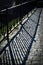 Iron railing shadow on stone pavement