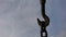 Iron silhouette of hooks and chains against a clear sky background