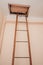 An iron staircase leads to the attic. Entrance to the attic in the ceiling