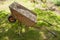 Iron wheelbarrow with gravel stands on the ground in the shade of a tree