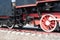 Iron wheels of mighty steam locomotives, red iron wheels of steam locomotives, steel wheels of a steam locomotive, steel power of