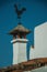 Iron wind vane over chimney on rooftop