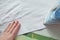 Iron and woman`s hand on white shirt on an ironing board