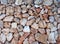 Irregular loose stone wall made of large textured brown and white limestone rocks with old twigs interwoven in the surface