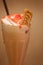 An irresistible duo of nutty and nice; peanut butter shake with strawberry jam and topped with whipped cream and a caramel biscuit