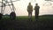 Irrigation agriculture. Two silhouette farmers working in the field examining installation for business irrigating corn