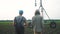 Irrigation agriculture. Two silhouette farmers working in the field examining installation for irrigating corn