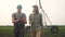 Irrigation agriculture. Two silhouette farmers working in the field examining installation for irrigating corn