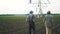 irrigation agriculture. two silhouette farmers working in the field examining installation lifestyle for irrigating corn