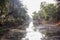 An irrigation canal passing through a forested countryside