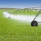 Irrigation equipment watering Spring crops in green farm field. Agriculture farming industry