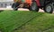 Irrigation of lawn by tractor with trailer tank.Panorama view.