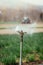 Irrigation plant system on a field, agriculture. Tractor in the blurry background