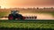 irrigation tractor driving spraying or harvesting an agricultural crop at sunset