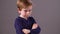 Irritated child with arms folded showing his back for frustration