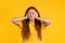 Irritated ginger woman with covered ears ignoring on yellow background. Teenager banning annoying sounds, shouts or