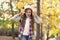 Irritated little girl suffer from loud unpleasant music sound cacophony in autumn park outdoors, headphones