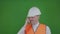 Irritated and nervous engineer or builder thinks about construction works. Chromakey. Boss or chief in a white helmet