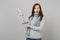 Irritated shocked young woman in gray sweater scarf swearing pointing hands aside on grey wall background