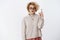 Irritated sulking and upset cute european female with blond short haircut in glasses and sweater pointing up with raised